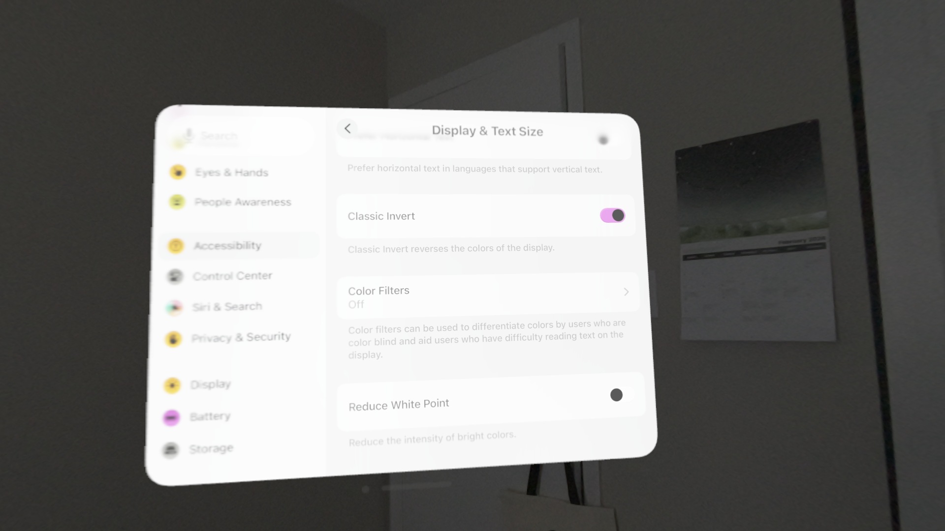 A screenshot of the Settings app on visionOS with Classic Invert enabled. The colors of all UI within the app window are inverted, resulting in dark text on a light translucent background. The passthrough video surrounding the window is not inverted.